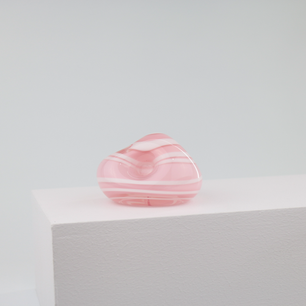 A little glass keepsake that will brighten up any desk, coffee table, or bookshelf. It is pink with a white swirl.