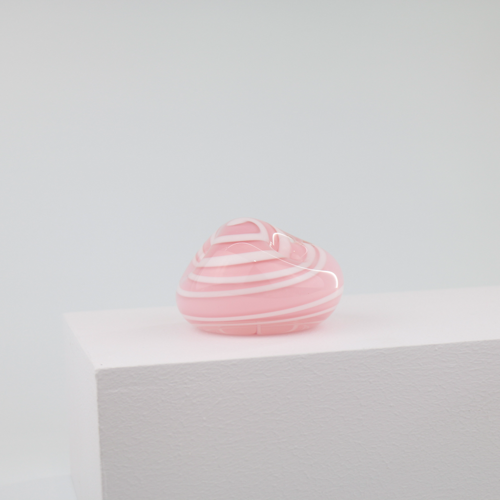 A little glass keepsake that will brighten up any desk, coffee table, or bookshelf. It is pink with a white swirl.