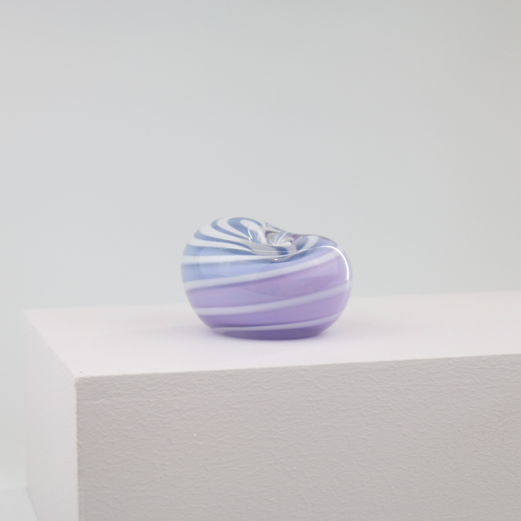 A little glass keepsake that will brighten up any desk, coffee table, or bookshelf. It is purple with a white swirl.